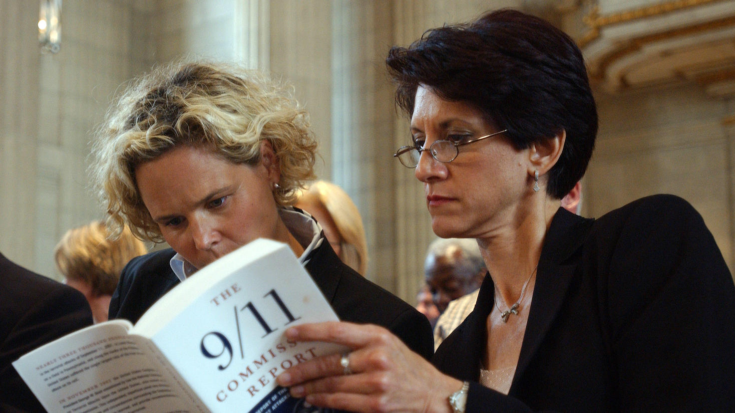 Kristen Breitweiser, left, and Lorie Van Auken look over the 9/11 report during a news conference to discuss the 9/11 Commission final report which was released on July 22, 2004, in Washington. (UPI Photo/Roger L. Wollenberg)